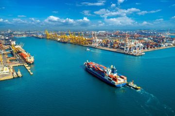 Aerial view of cargo ship and cargo container in harbor.